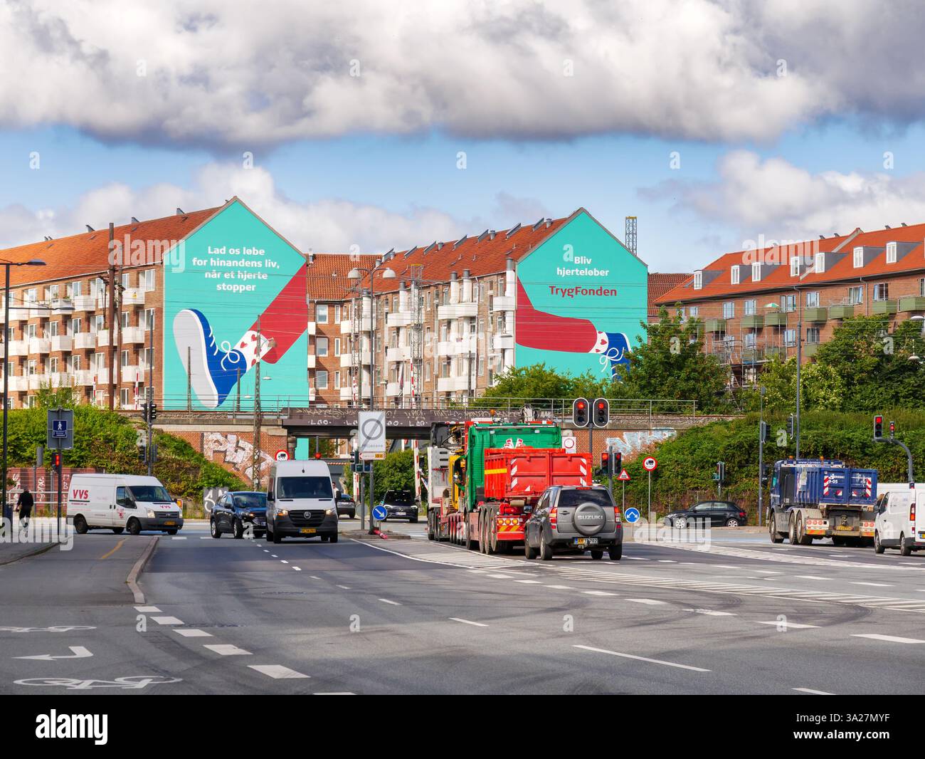 Copenhagen, Sundkrogsgade traffic, railway viaduct and apartment buildings with large TrygFonden health awareness mural, Nordhavn, Denmark Stock Photo