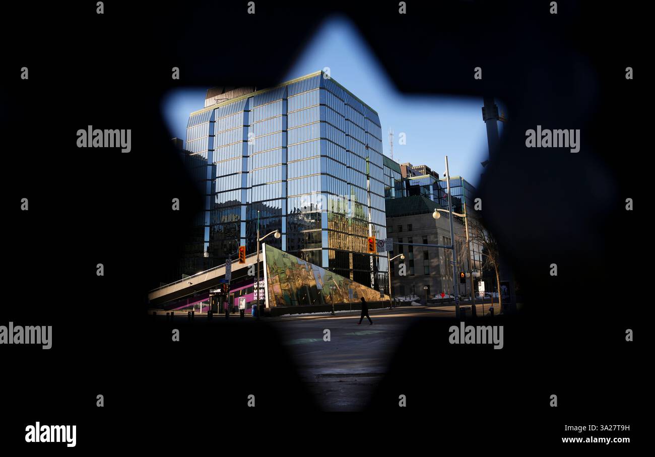 The Bank of Canada is framed through the west gate of Parliament in