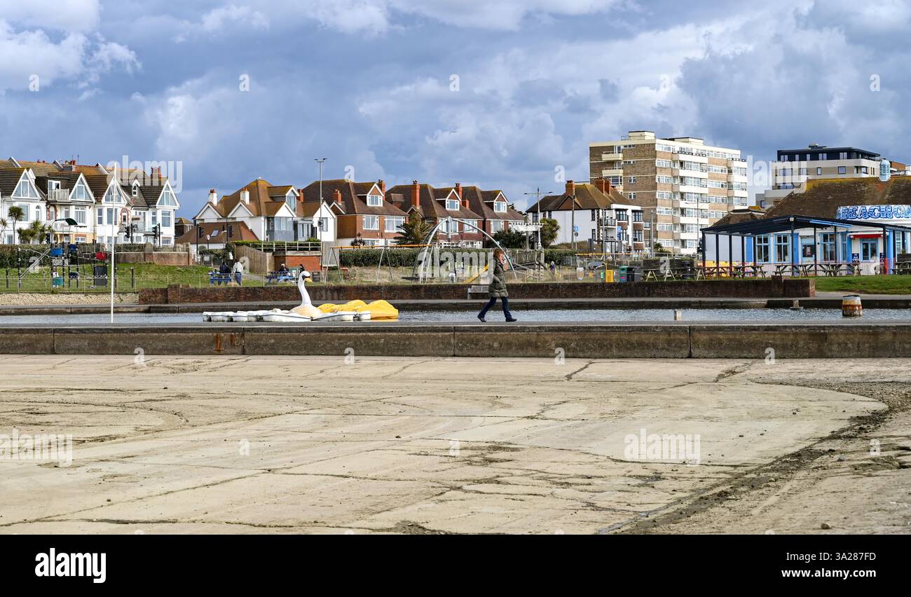 Brighton UK 12th March 2025 A walker passes by Hove Lagoon which has been drained for