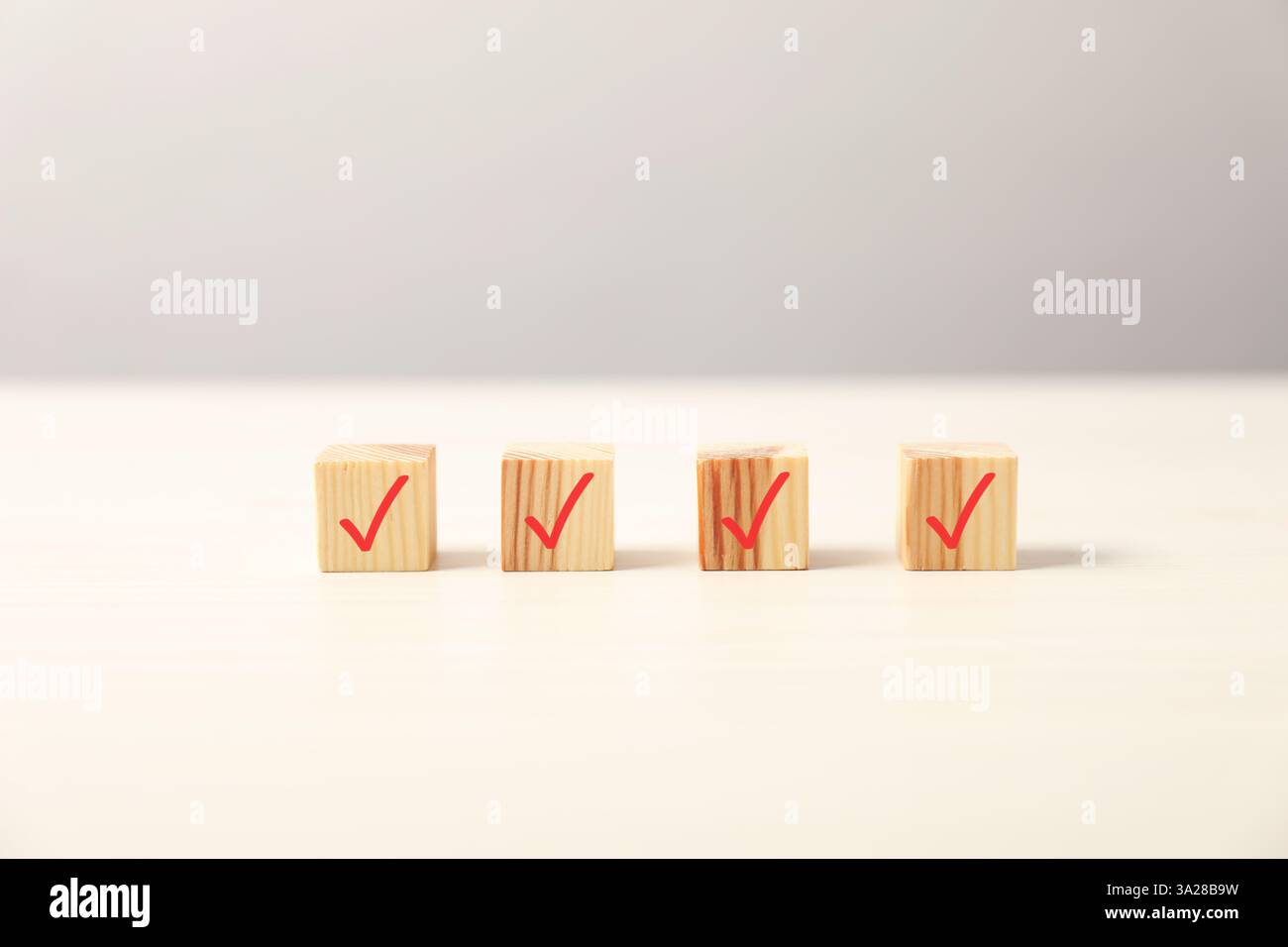 Wooden cubes with check marks on light table Stock Photo