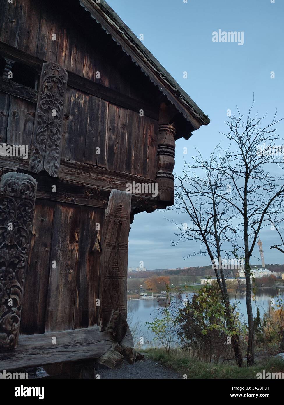 Traditional carved wooden house at Skansen open-air museum with view of Kaknastrornet in Stockholm, Sweden - Smartphone Captured Stock Image
