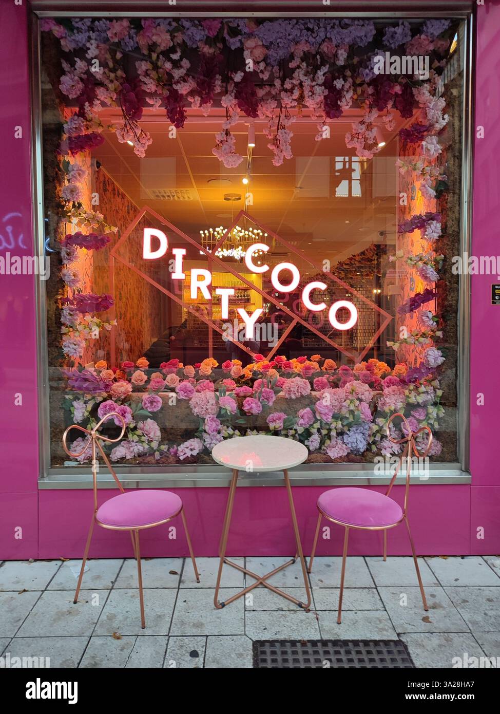 Colorful floral window display with neon sign at Dirty Coco café in Stockholm, Sweden - Smartphone Captured Stock Image