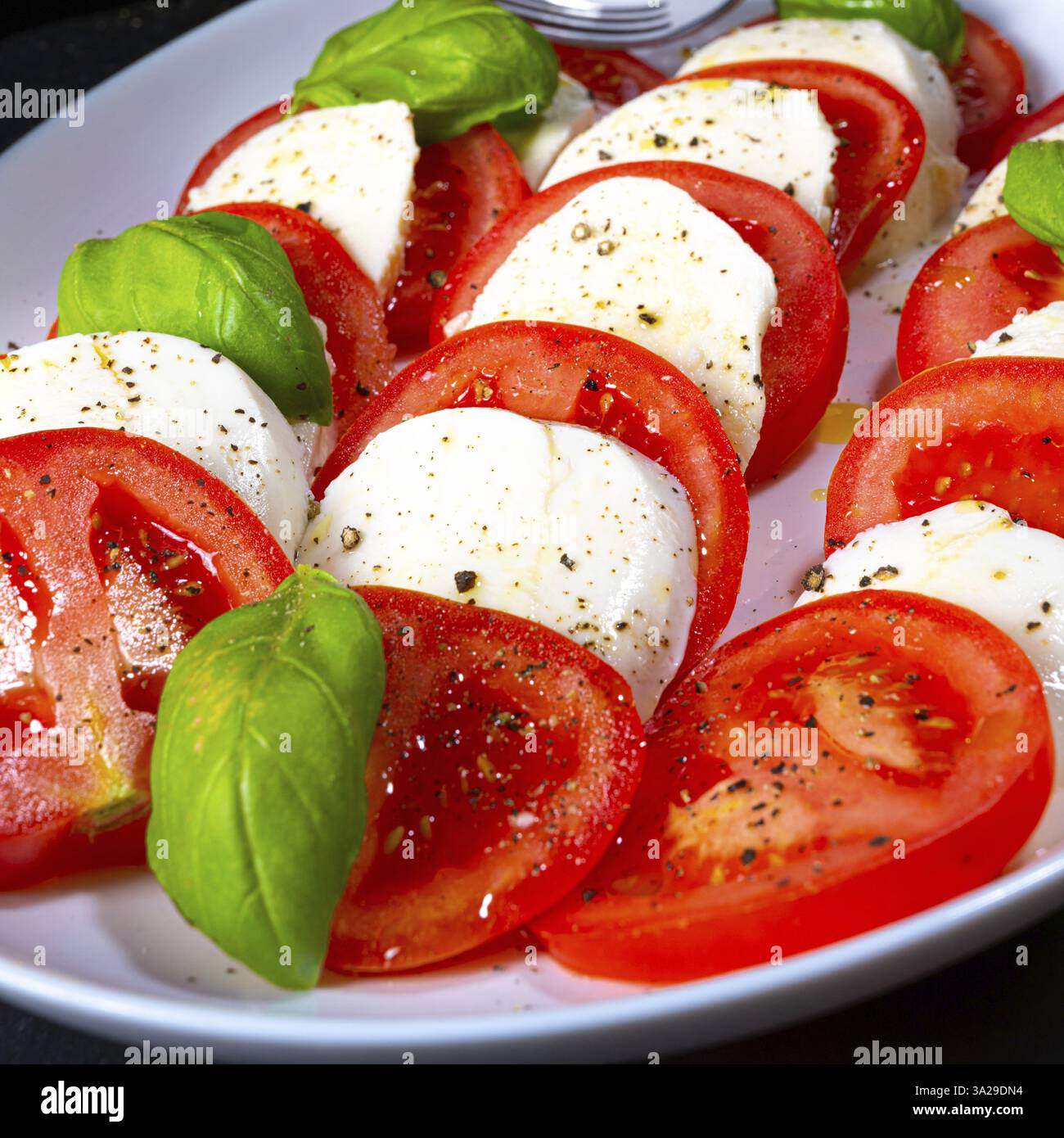 Tomatoes with mozzarella and basil Stock Photo - Alamy