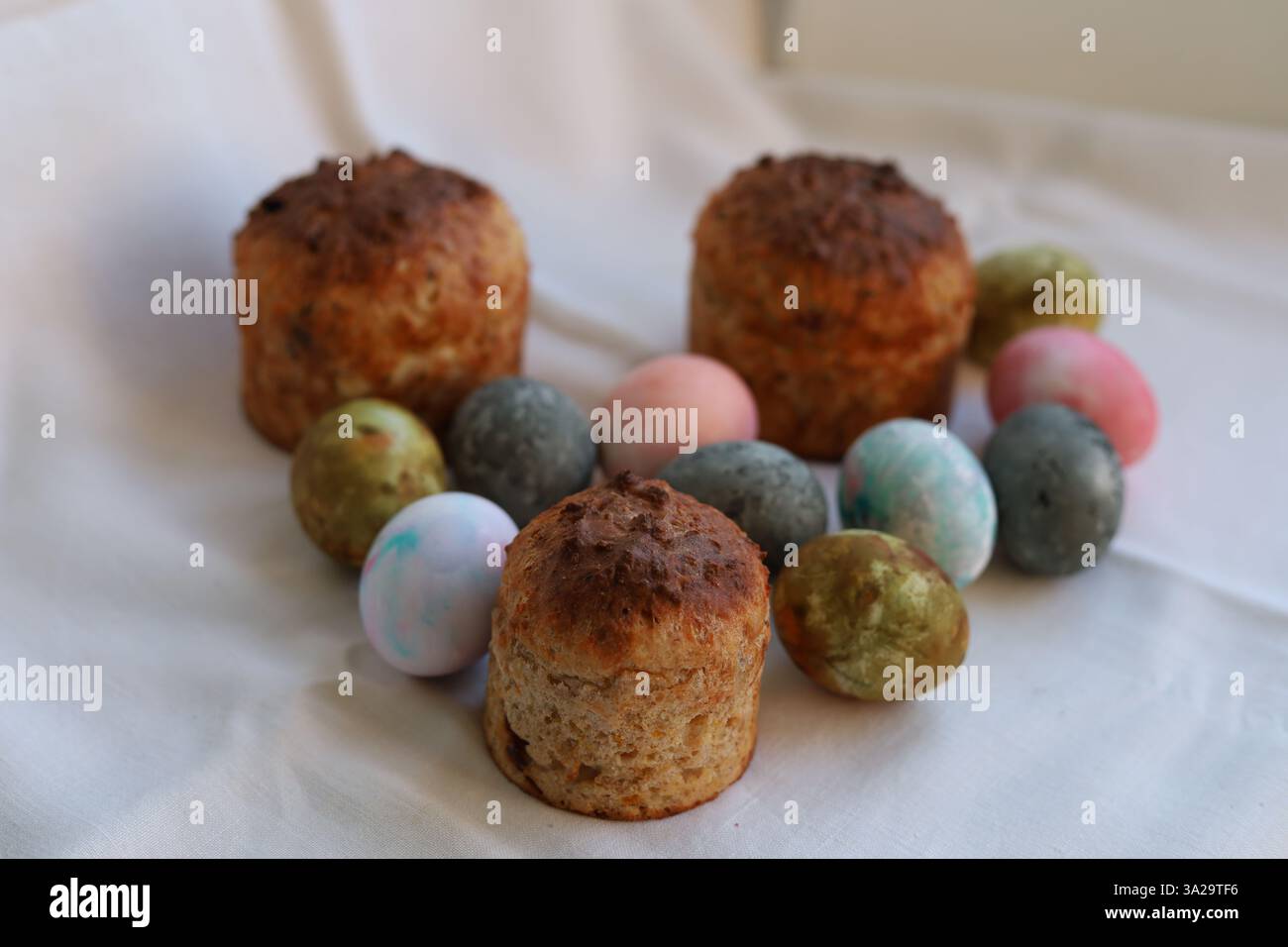 Easter cakes and colorful Easter eggs on a white tablecloth Stock Photo