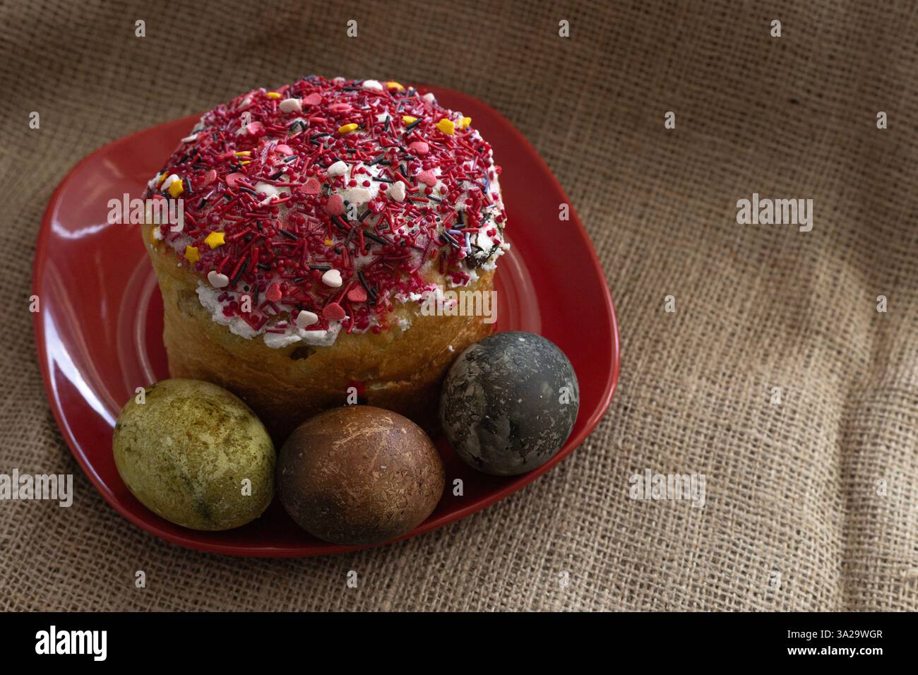 Easter cake with Easter eggs on a red plate Stock Photo
