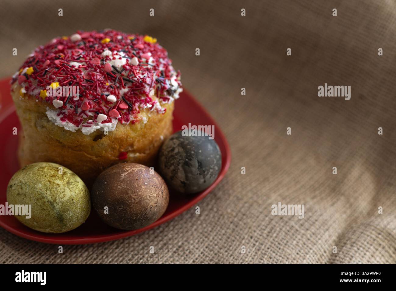Easter cake with three Easter eggs in a red plate on the table Stock Photo