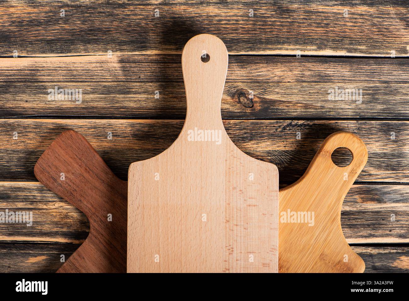 Gastronomic concept, several cutting boards on a dark rustic wooden table, top view. Stock Photo