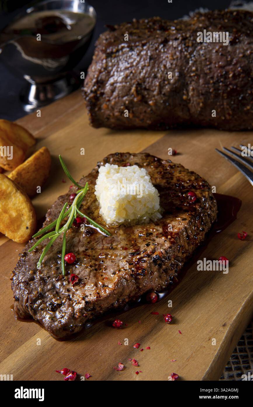 Butter beef steak with herbs and potato wedges Stock Photo - Alamy