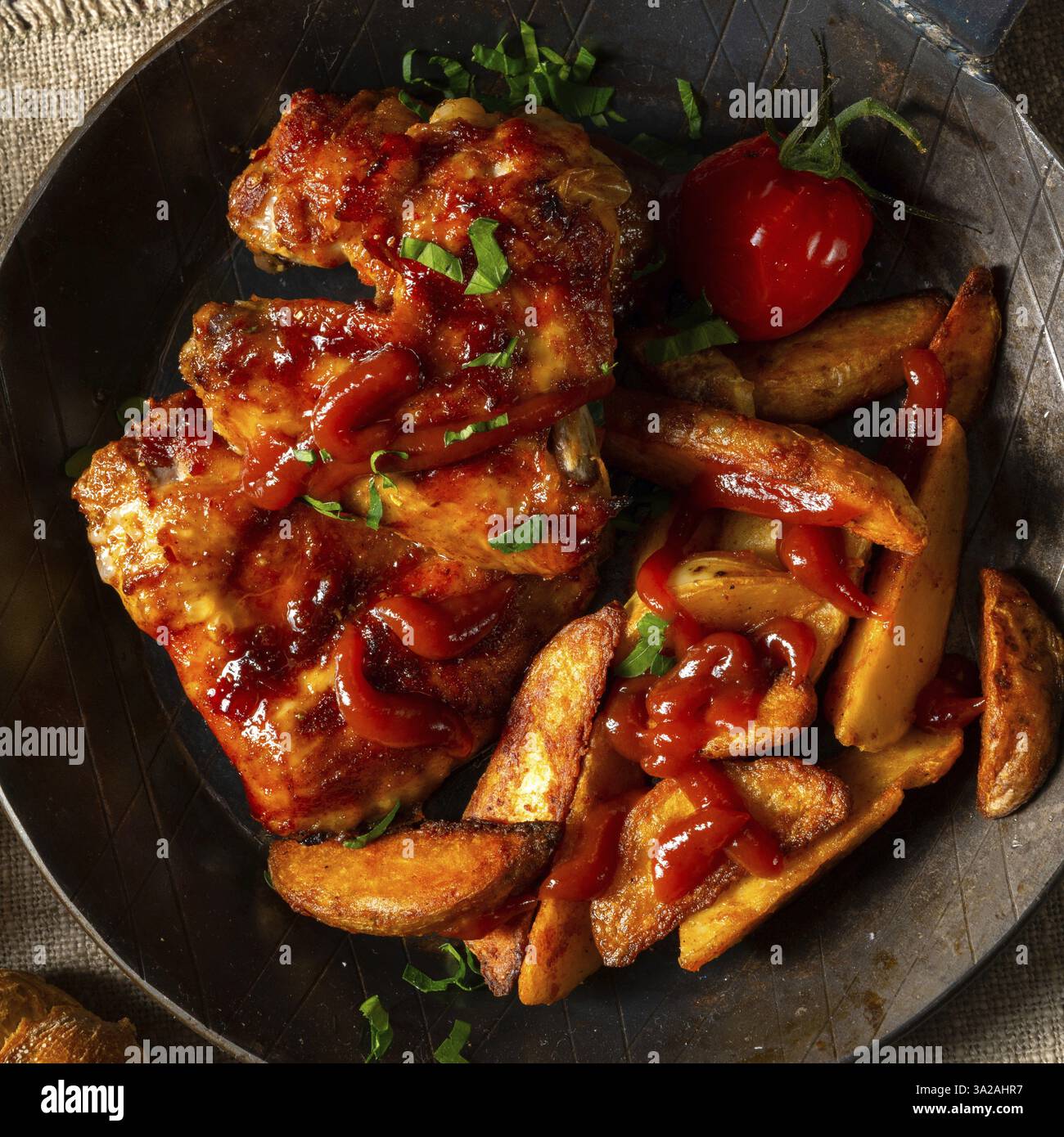 Rustic chicken wings in honey with potato wedges Stock Photo - Alamy