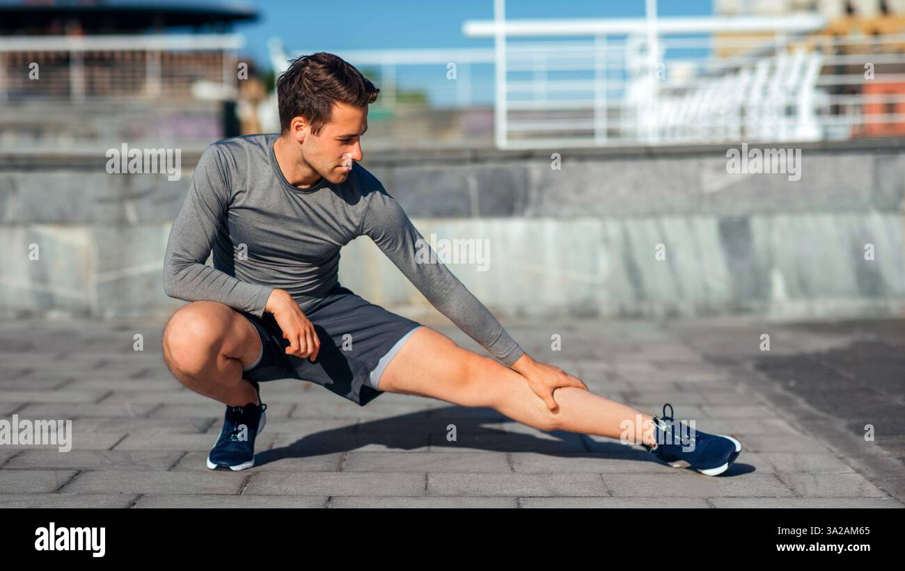 Athletic body and healthy lifestyle. Man squatting and doing leg ...