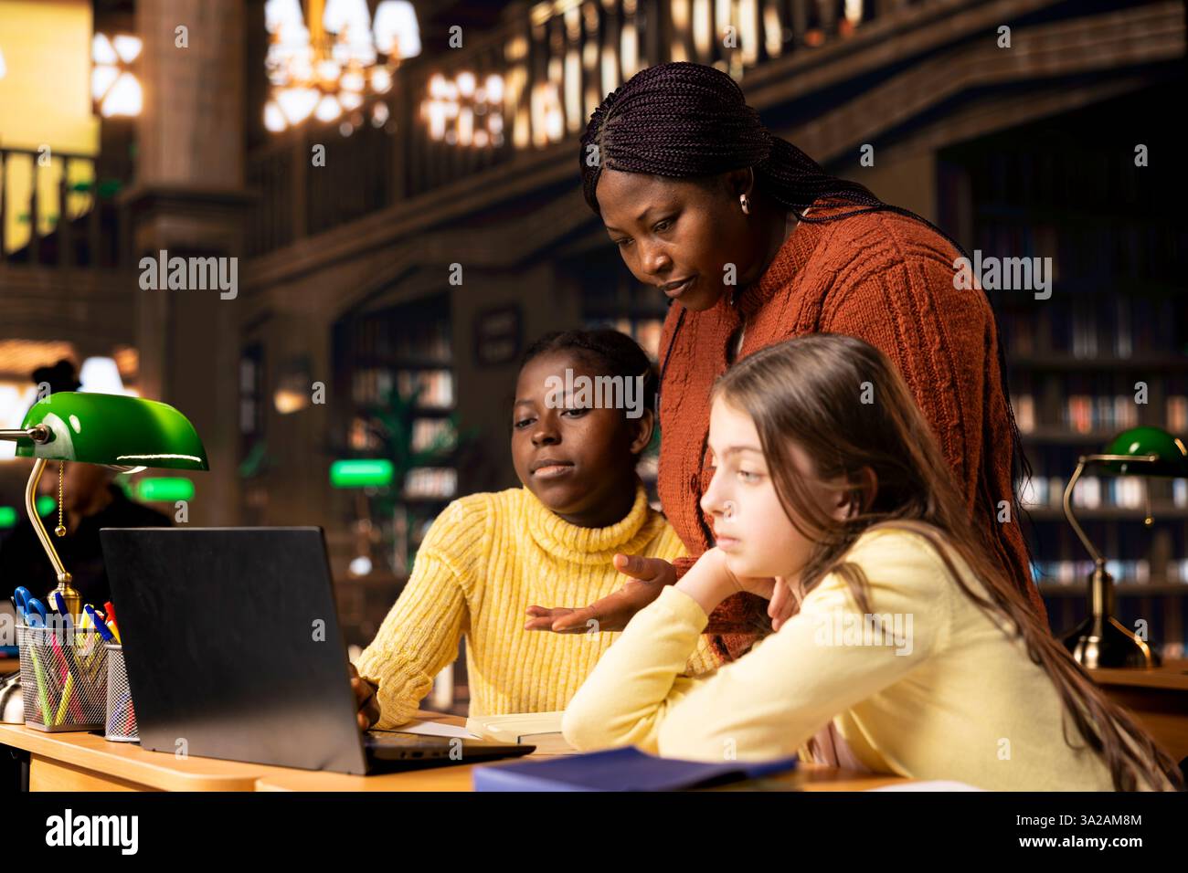 Two elementary school children working with a tutor practicing ...