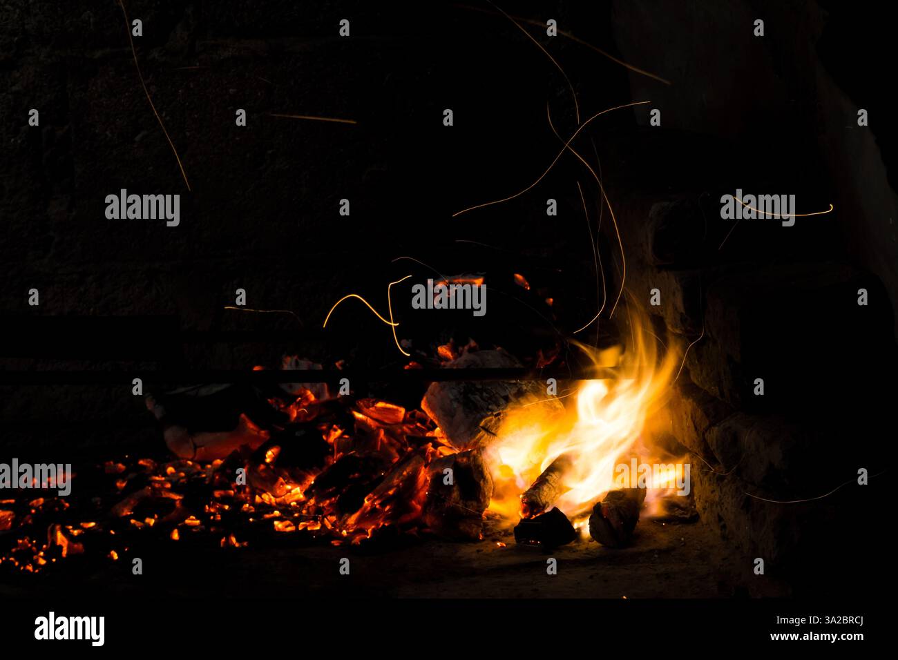 Campfire flames in the dark, with spark trails Stock Photo - Alamy
