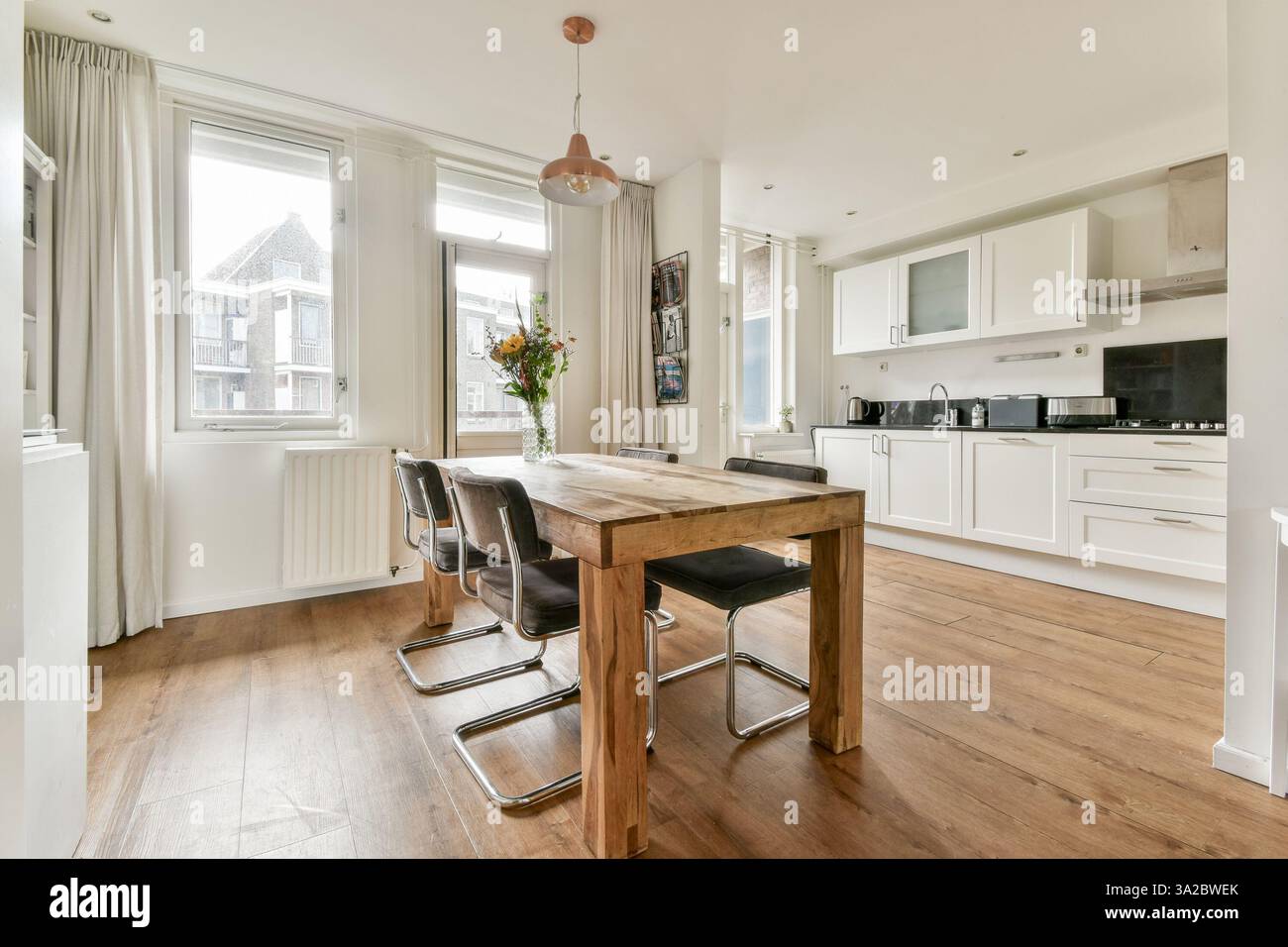 A bright and airy modern dining area featuring a wooden table, stylish ...