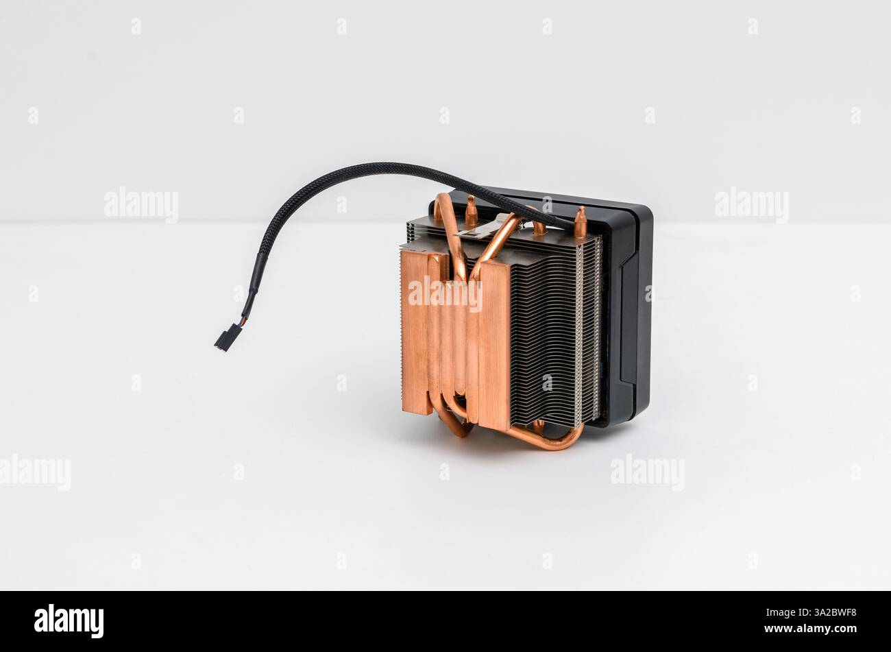 Copper heat sink or heat pipe or computer processor cooler with radiator and fan on white background. Stock Photo