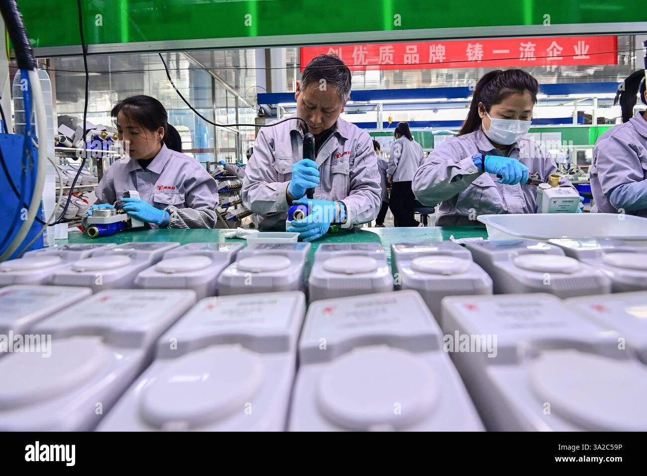 QINGZHOU, CHINA - MARCH 9, 2025 - Workers assemble smart water meters ...