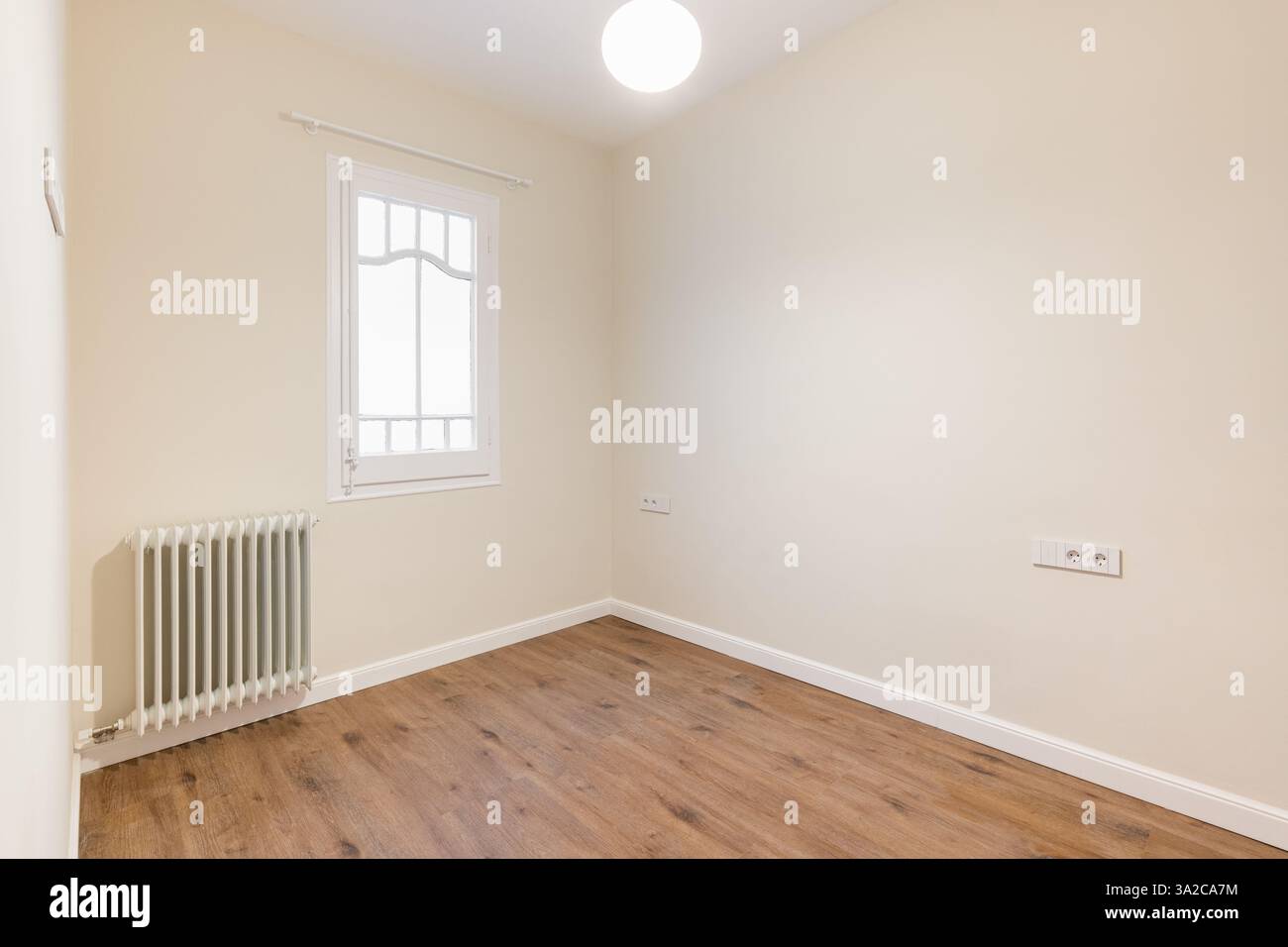 Simple empty bedroom with wooden flooring and a single window Stock ...