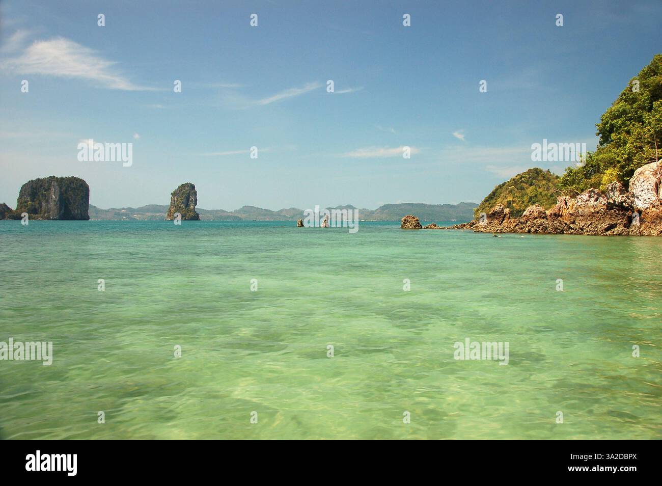 Limestone karst islands of Hong Island rise from the turquoise waters of the Andaman Sea under a clear blue sky in southern Thailand Stock Photo