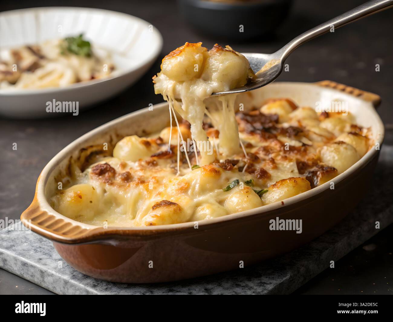 A classic French-inspired comforting dish, Creamy French Onion Gnocchi Bake, elegantly plated on rustic wooden serveware. Stock Photo