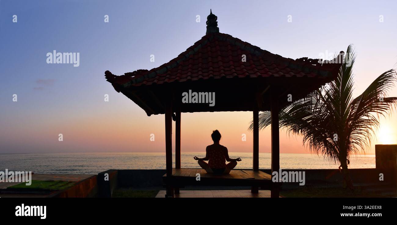 Woman doing yoga in the morning with a view of the Indian Ocean, Indonesia, Bali, Nusa Penida, Karangsari Stock Photo