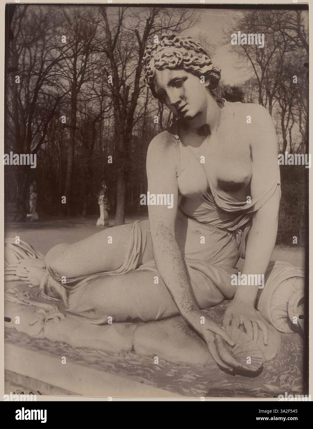 In this photograph, Eugène Atget captures the statue of a nymph holding ...