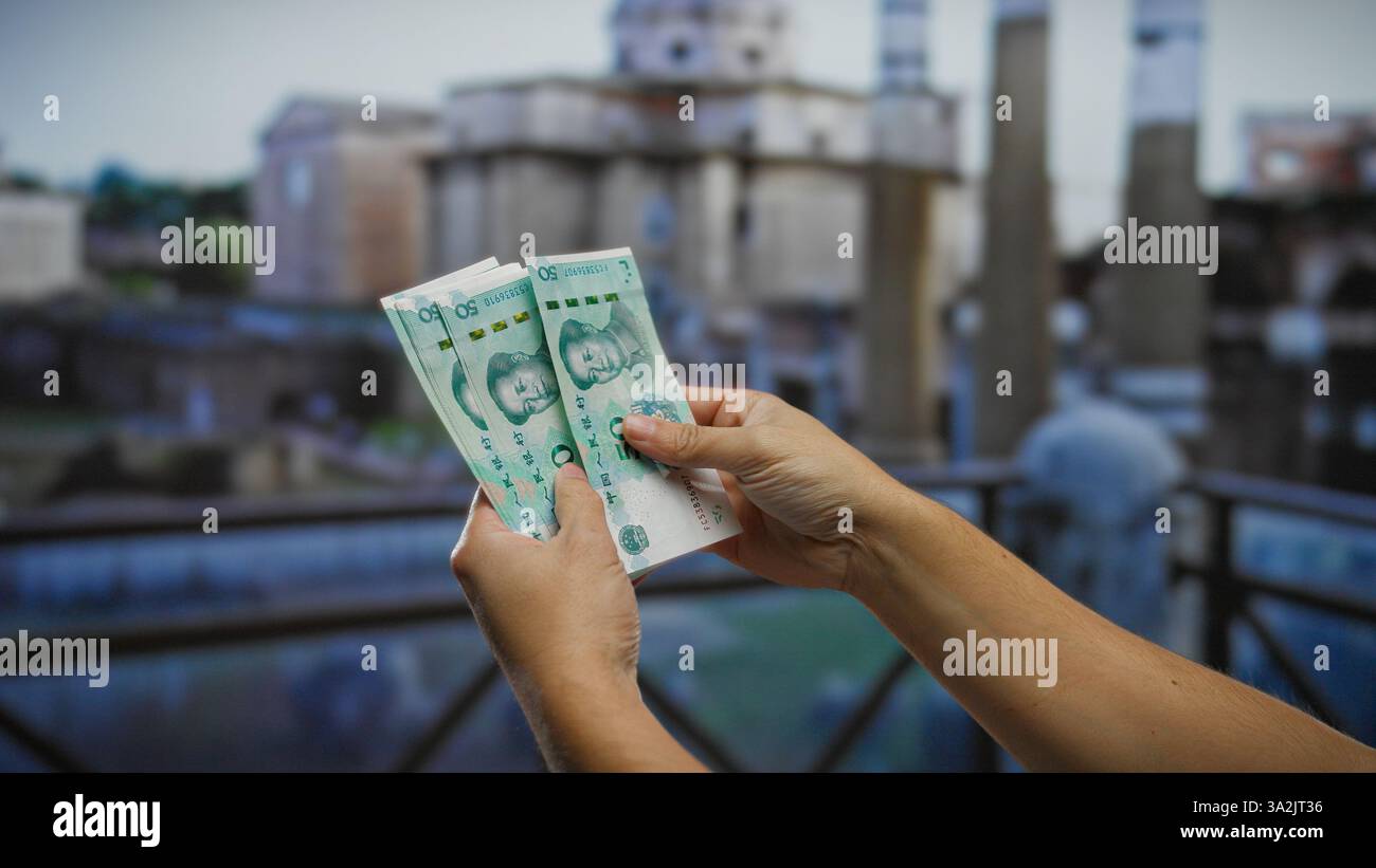 Hands counting chinese yuan banknotes outdoors in an urban roman ...