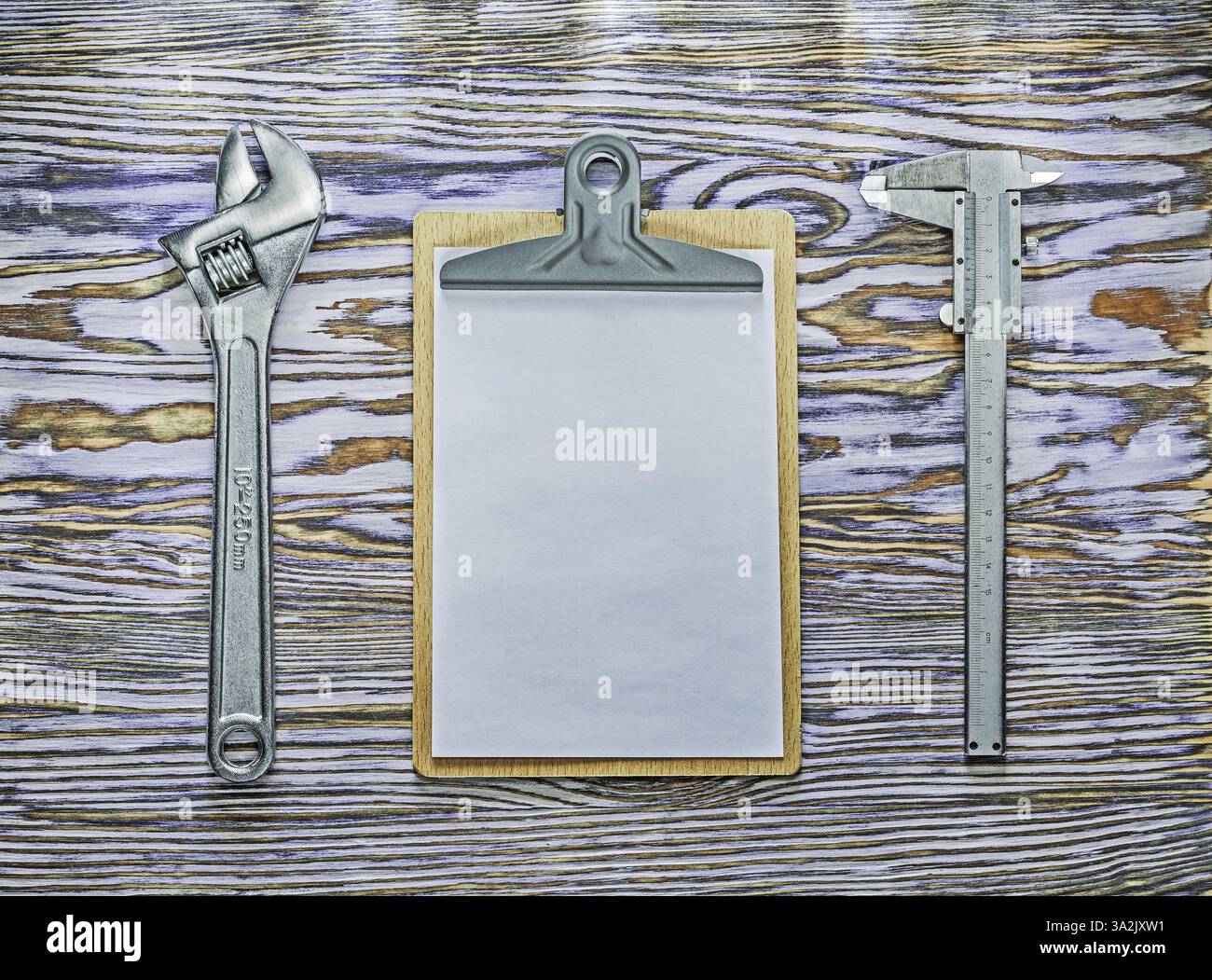 Vernier caliper adjustable spanner clipboard on wooden board Stock Photo