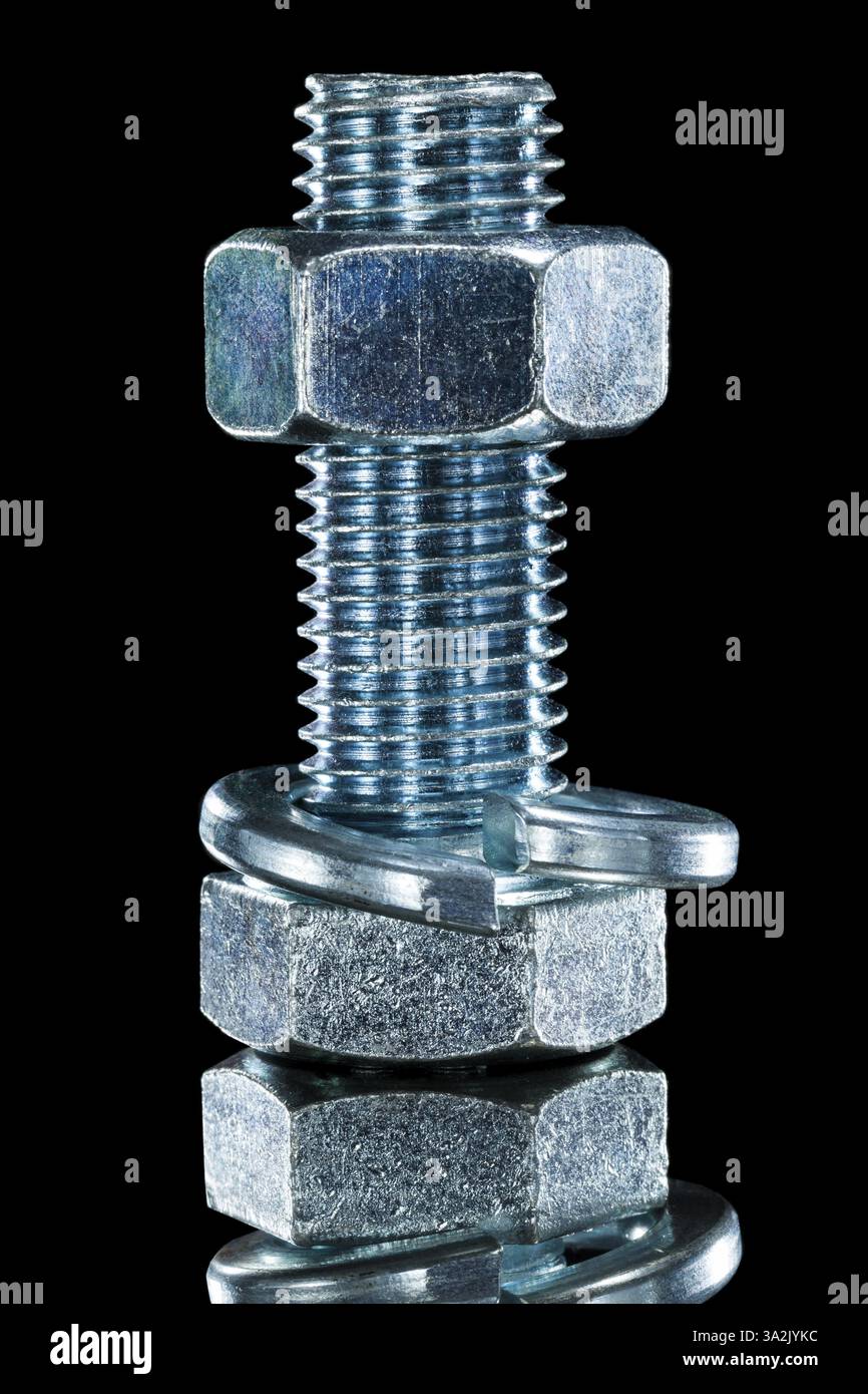 Threaded construction nut screwbolt spring washer on black surface Stock Photo