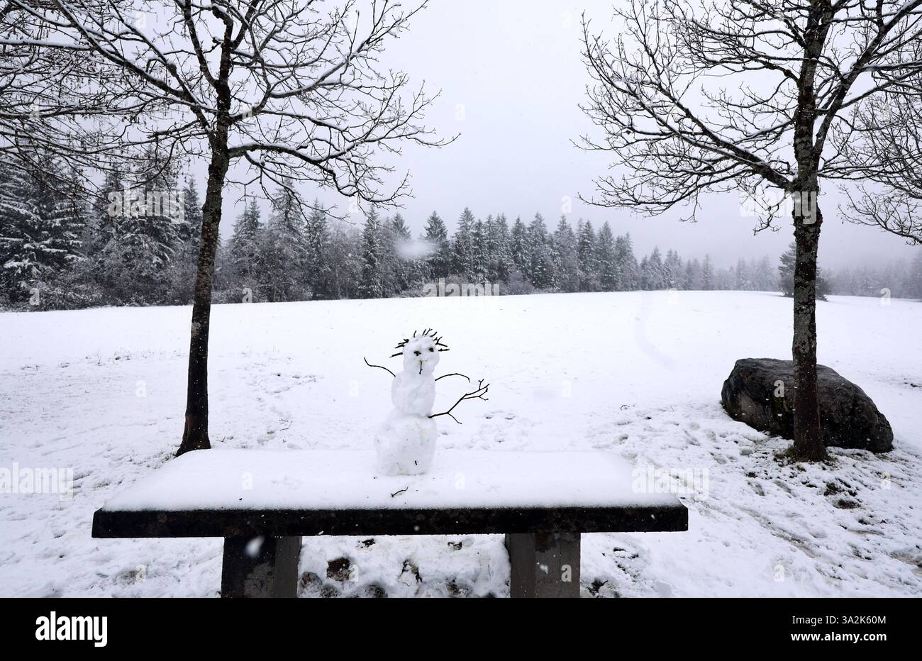 13 March 2025, Bavaria, Bad Hindelang A small snowman stands on a table in the snow at a rest
