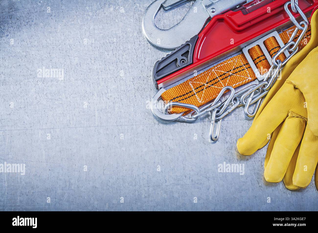 Safety belt protective gloves construction level on metallic background Stock Photo