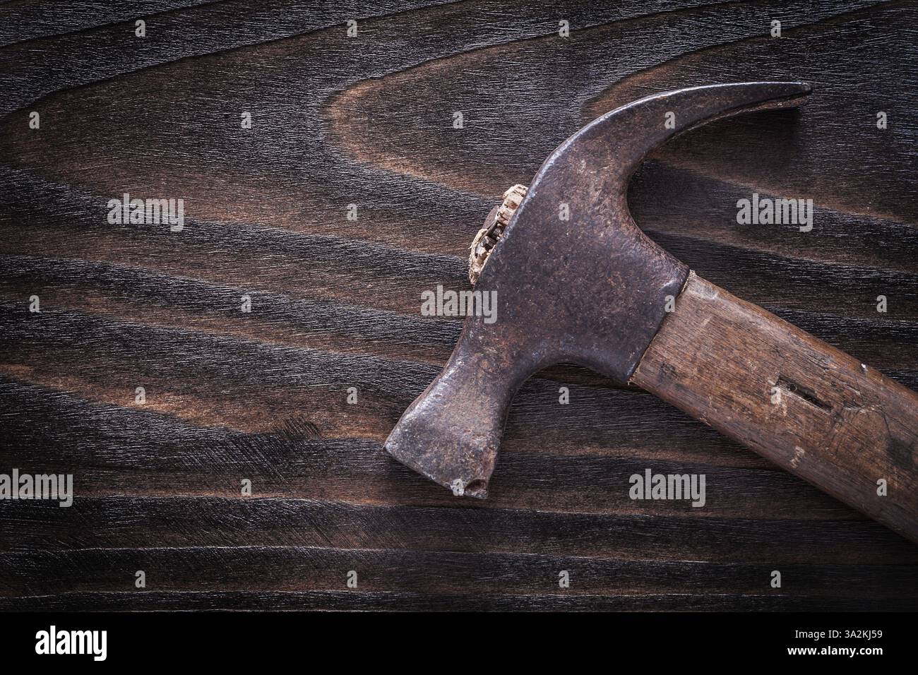 Rusty metal claw hammer with wooden handle on vintage dark wooden board ...