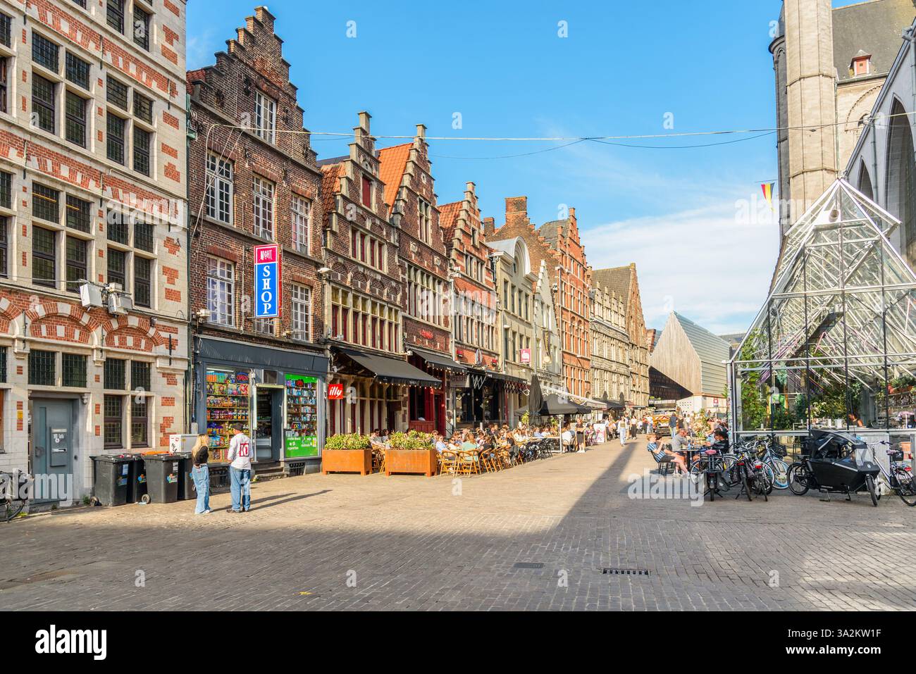 Ghent, Belgium - July 10, 2024: people sitting at outdoor restaurant tables for dinner in the old city centre on a sunny evening Stock Photo