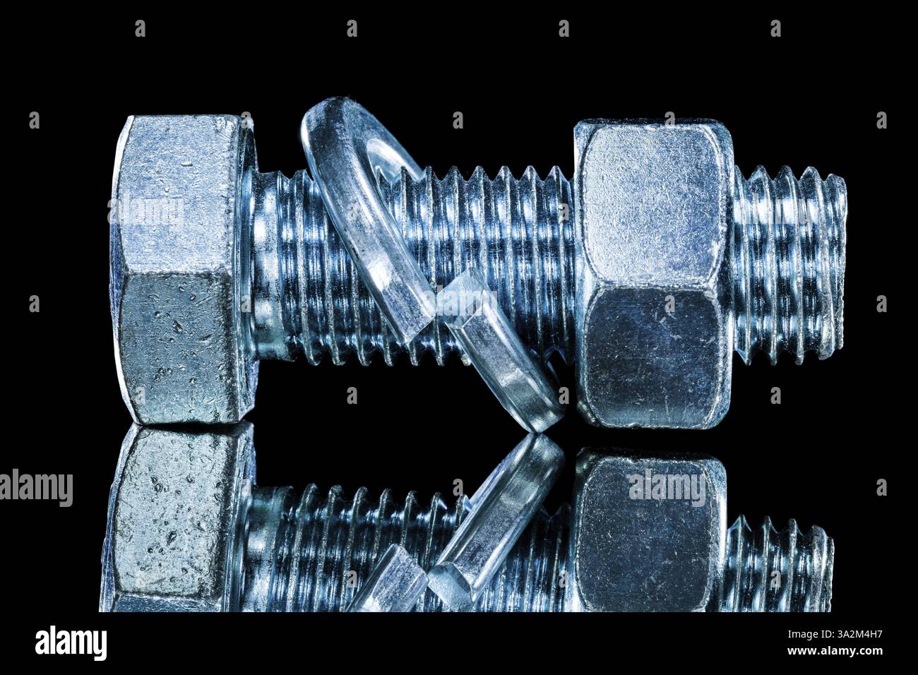Stainless nut screwbolt spring washer on black surface Stock Photo