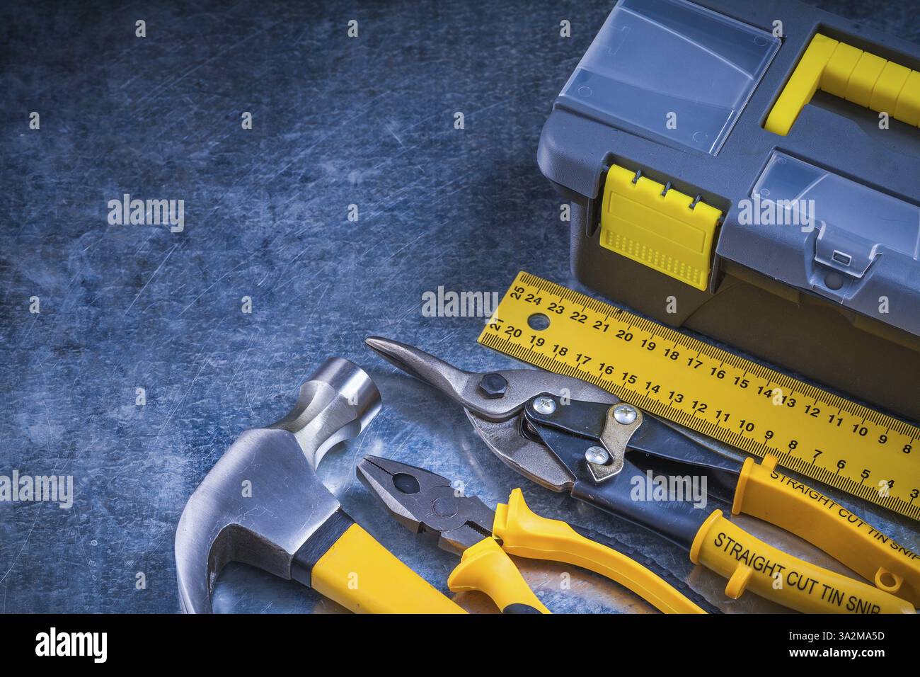 Scratched metallic background with toolbox hammer ruler pliers and tin ...