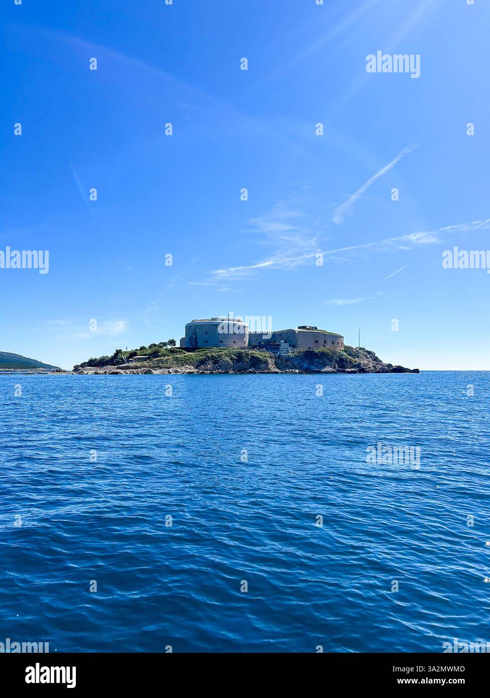 Mamula Island in Herceg Novi, Montenegro, surrounded by crystal-clear blue waters. The historic fortress stands on the island. - Smartphone Captured Stock Image