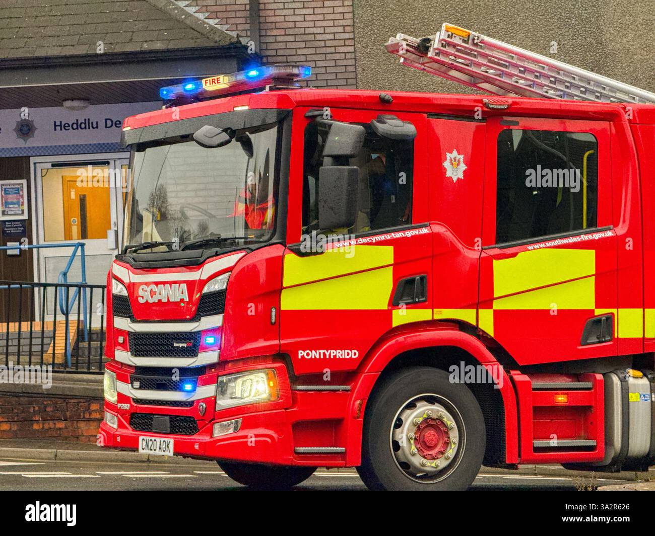 Pontypridd, Wales, UK - 24 November 2024: Fire engine of the South Wales Fire and Rescue Service with blue lights flashing on an emergency call - Smartphone Captured Stock Image