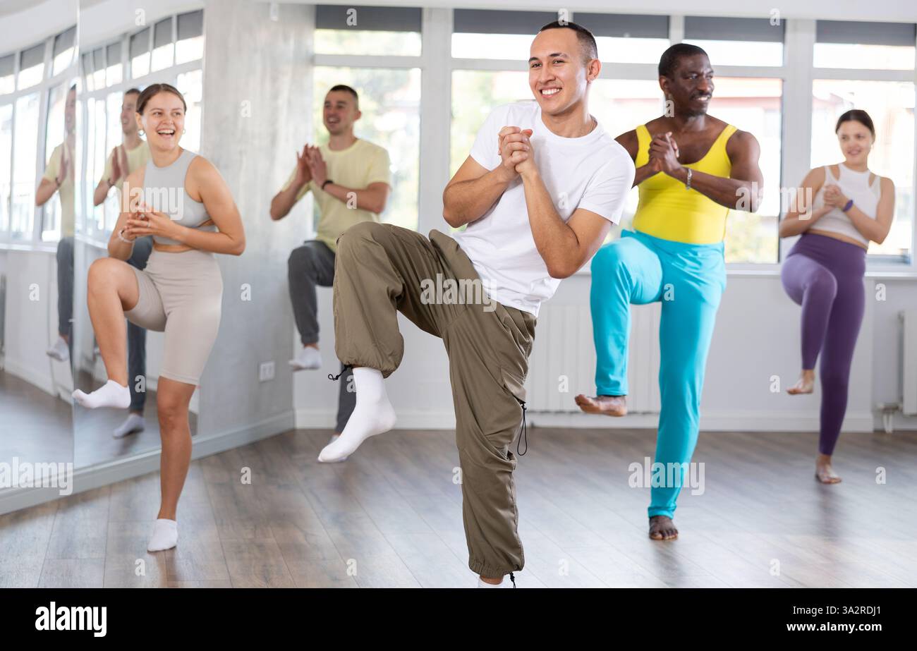 Young Asian male instructor guiding group through zumba routine Stock ...