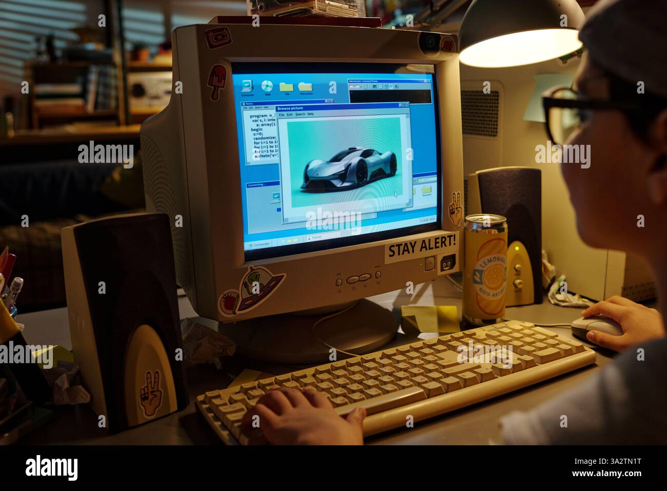 Child enthusiastically designing virtual car model on vintage computer monitor using CAD software while working on creative project in cozy room Stock Photo