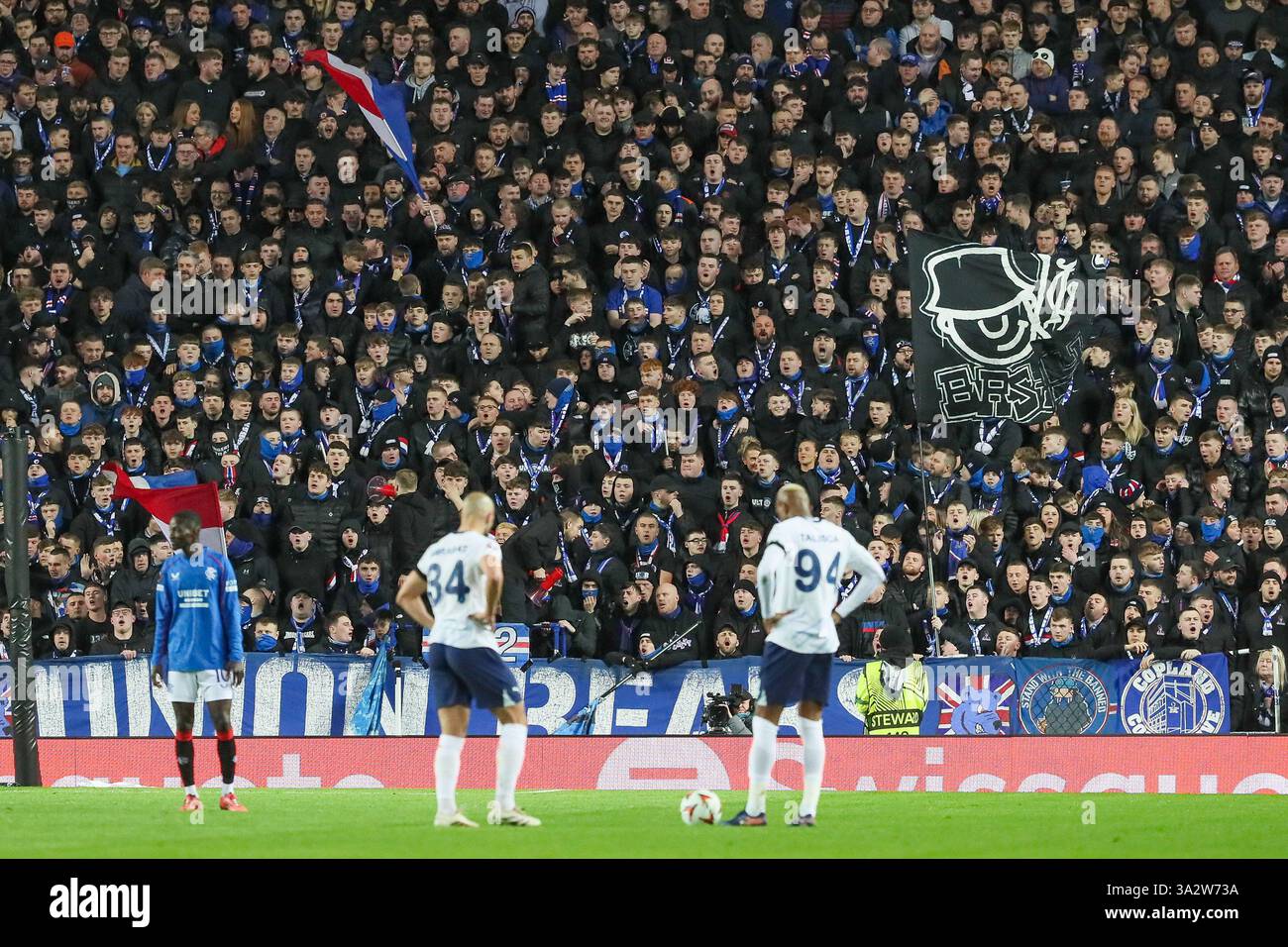 !3 March 2025, Glasgow, UK. Rangers played Fenerbahce at Ibrox Stadium, Glasgow, Scotland, in the second leg, Round 16 of the Europa League. Rangers won 1 - 3 (away) in the first leg and Fenerbahce won 0 - 2 in the second leg. The game went to penalties and Rangers won 3 -2. Rangers progress to the next round. Talisca (F94) and Sofyan Amrabat (34) , about to take a free kick are barracked by the Union Bears, Rangers supporters. Credit: Findlay/Alamy Live News Stock Photo
