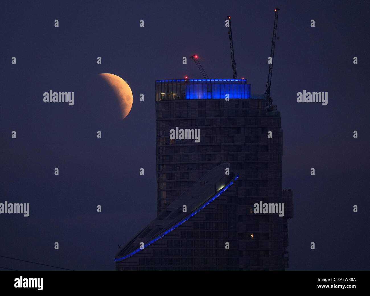 A lunar eclipse is visible above Canary Wharf in London as the full ...