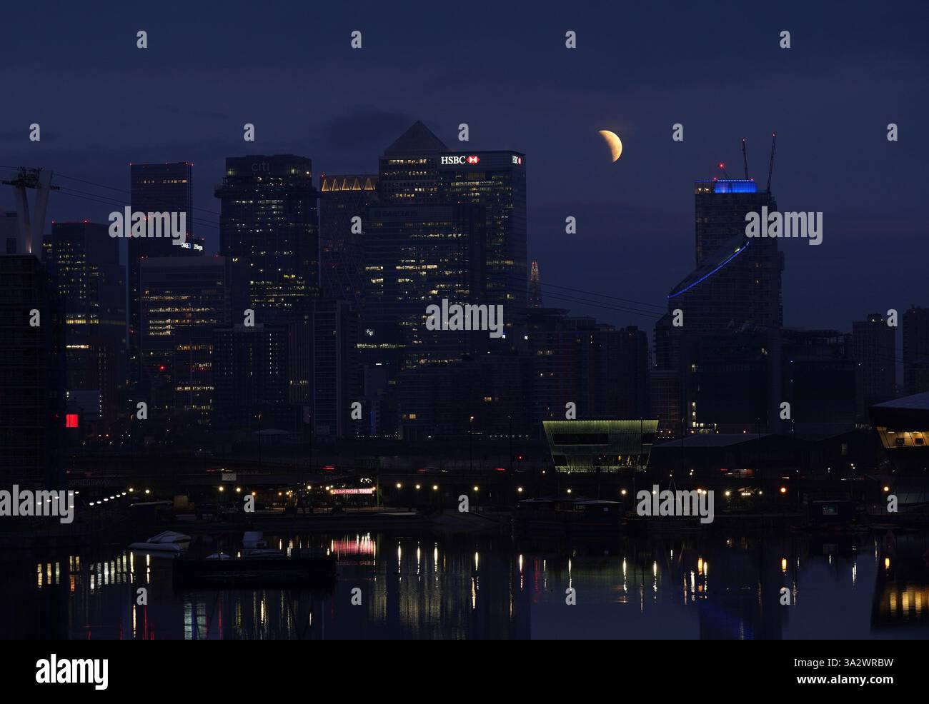 A lunar eclipse is visible above Canary Wharf in London as the full ...
