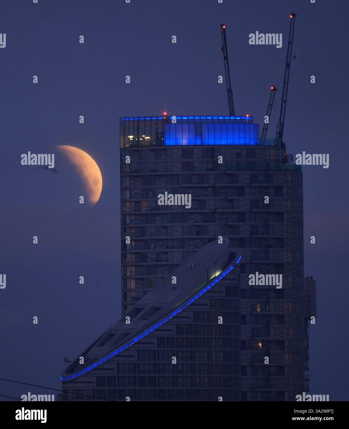 A lunar eclipse is visible above Canary Wharf in London as the full ...