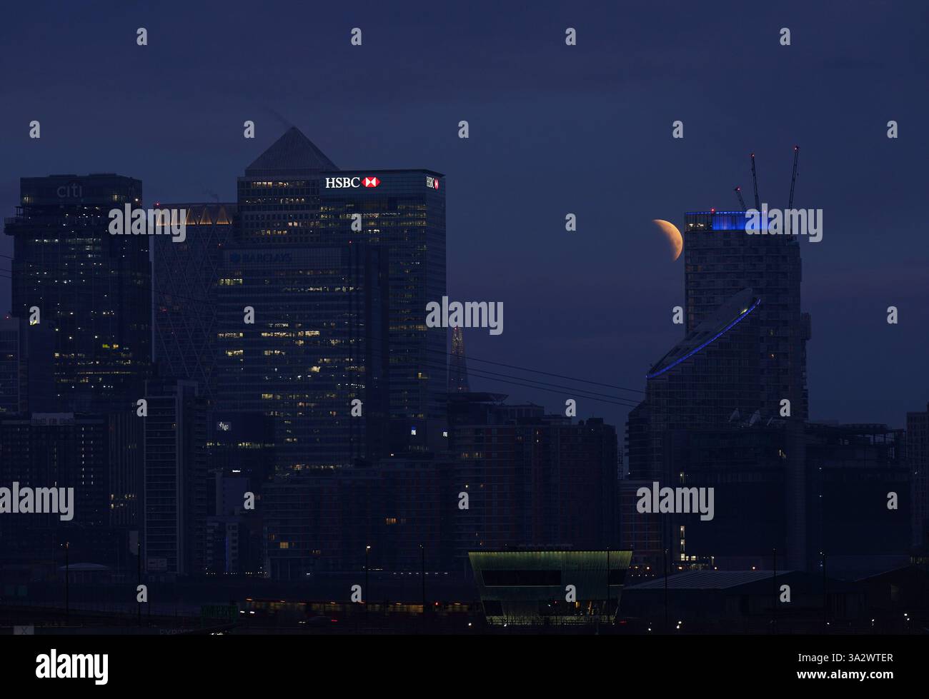 A lunar eclipse is visible above Canary Wharf in London as the full ...