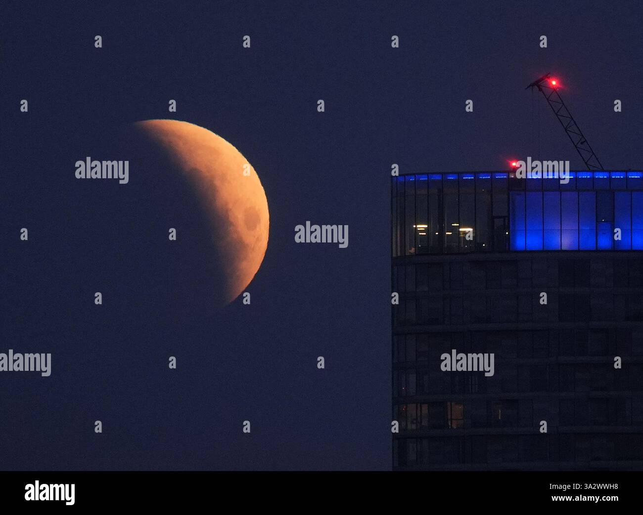 A lunar eclipse is visible above Canary Wharf in London as the full ...