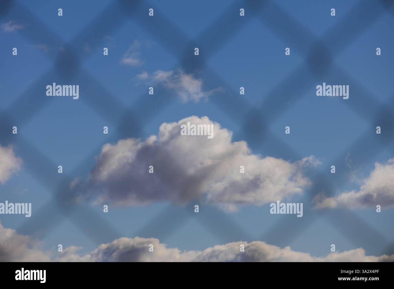 sky with white clouds viewed through a wire fence Stock Photo - Alamy