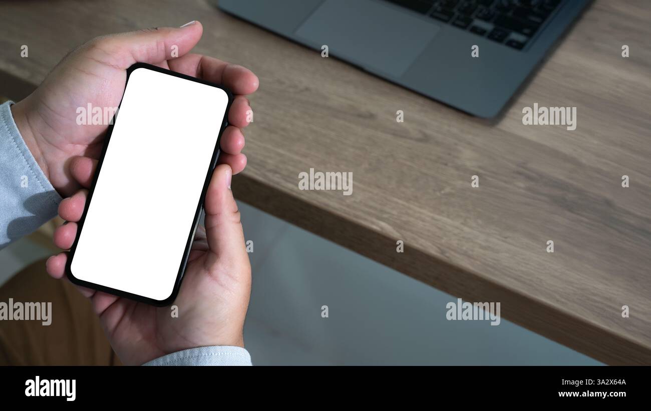 Top view Mockup image hand using a smartphone man Holding Cell Phone With Blank Screen Stock Photo