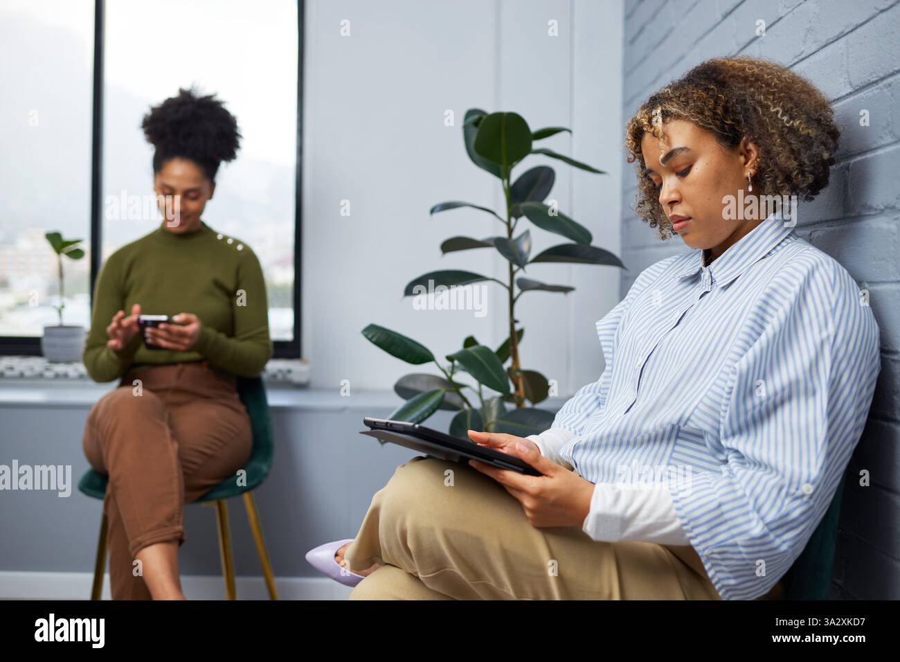 Professionals Sitting in a Modern Office Space and Using Digital Devices Stock Photo