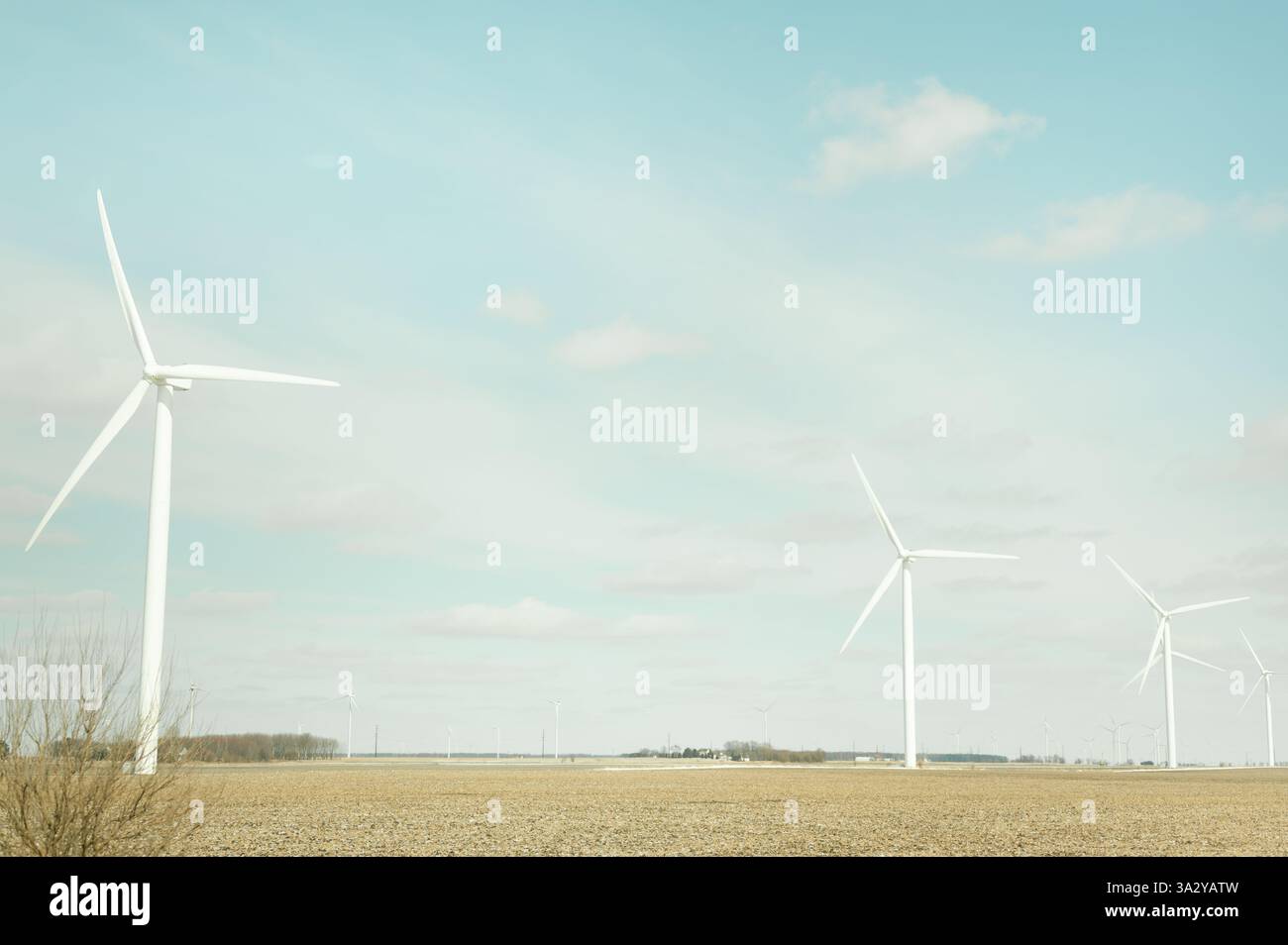Multiple wind turbines stand in an open Indiana field with copy space Stock Photo