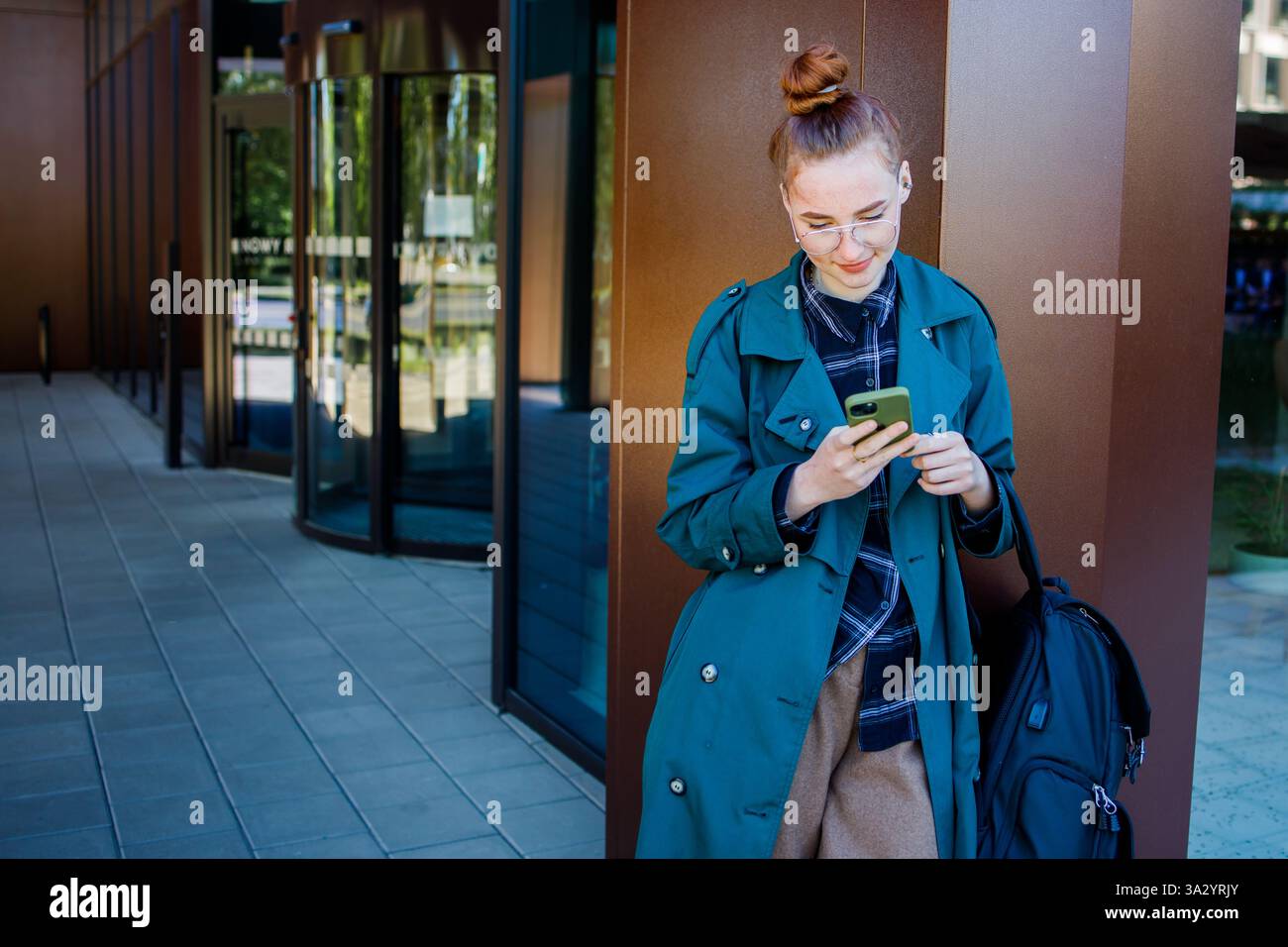 Student ginger girl using a smartphone Stock Photo