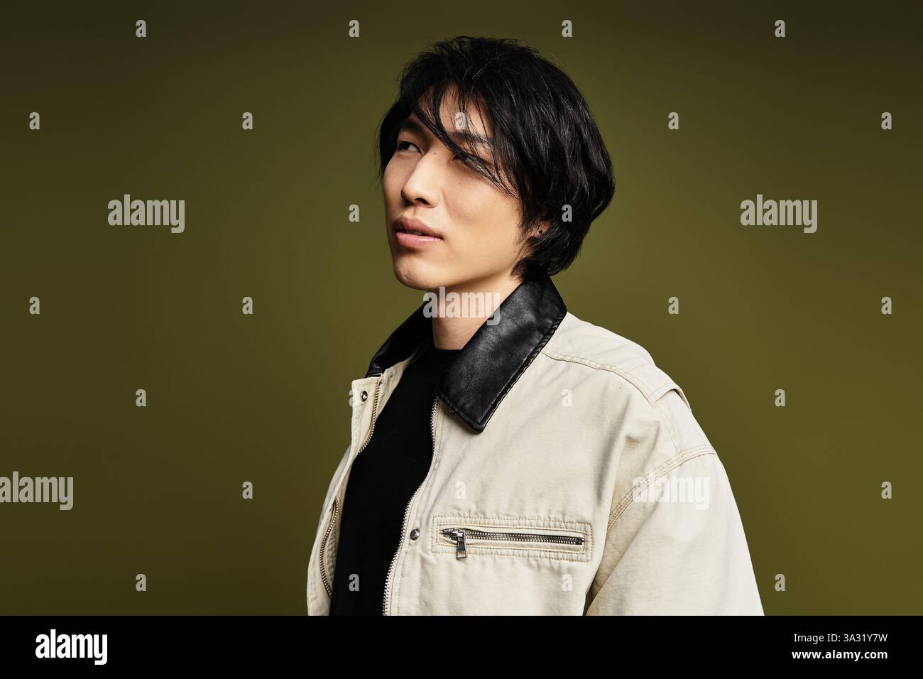 A stylish young man poses confidently in a studio with a striking ...