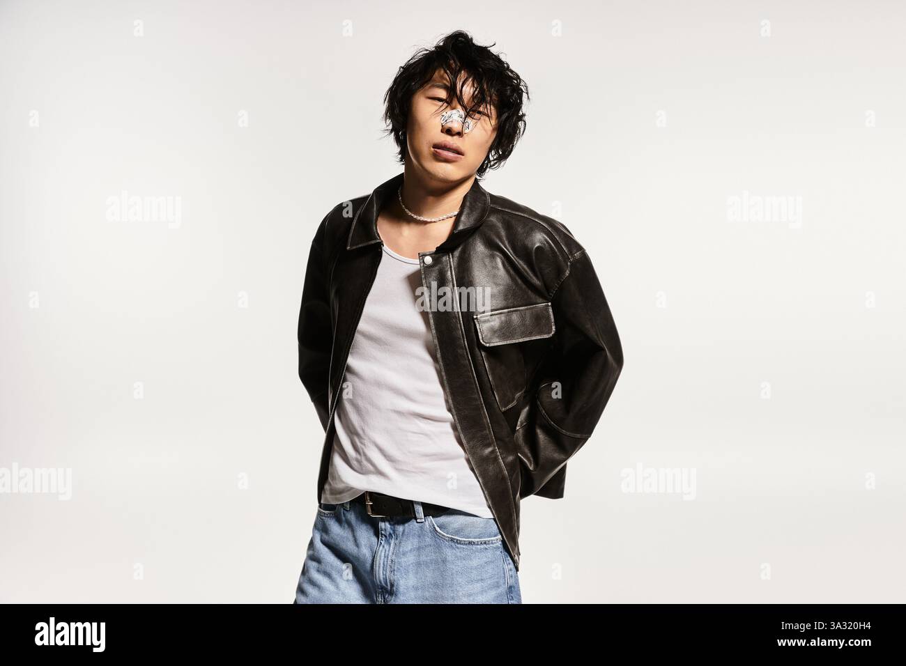 Stylish Asian man in studio poses in leather jacket and modern clothes ...